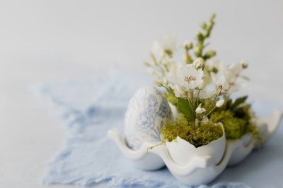 tafelstuk met witte bloemen en een paasei